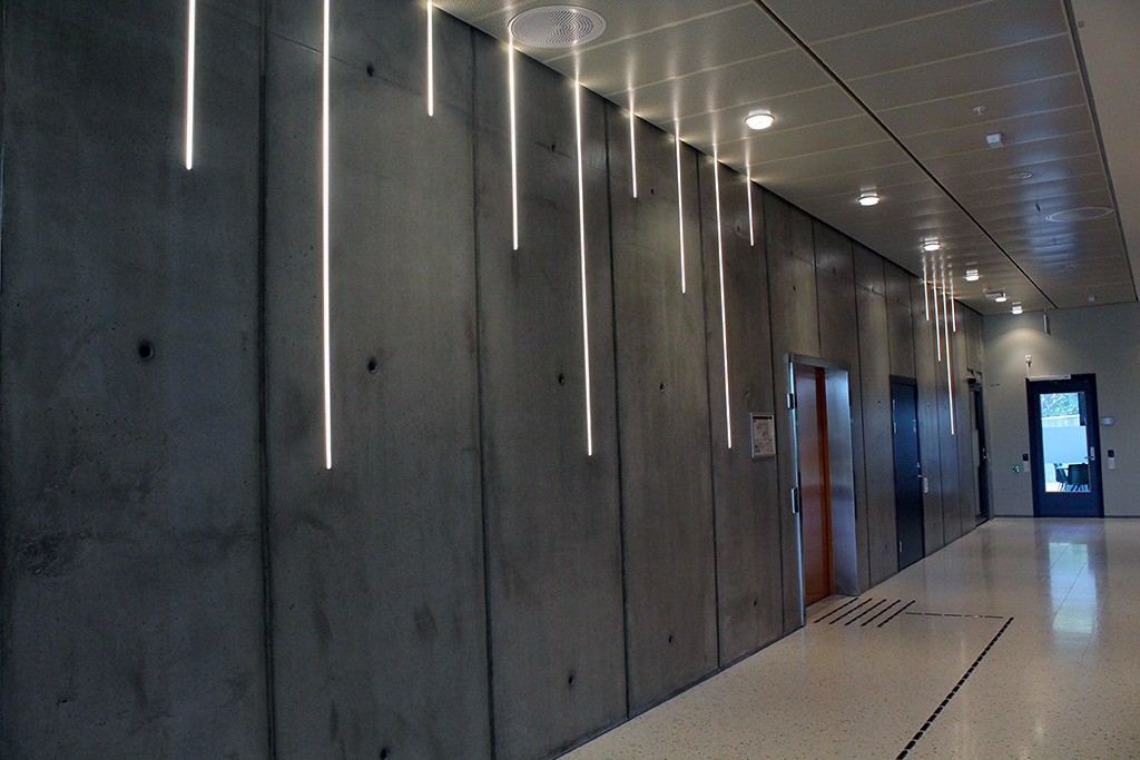 Ved hovedinngangen ser du blant annet enn vegg med frilagt betong og vakker lyssetting. Foto: Silje Ulveseth